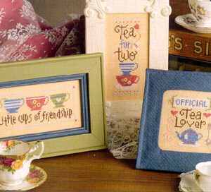 Framed tea-themed cross-stitch and teacups