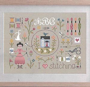 Framed cross-stitch sampler with house and sewing